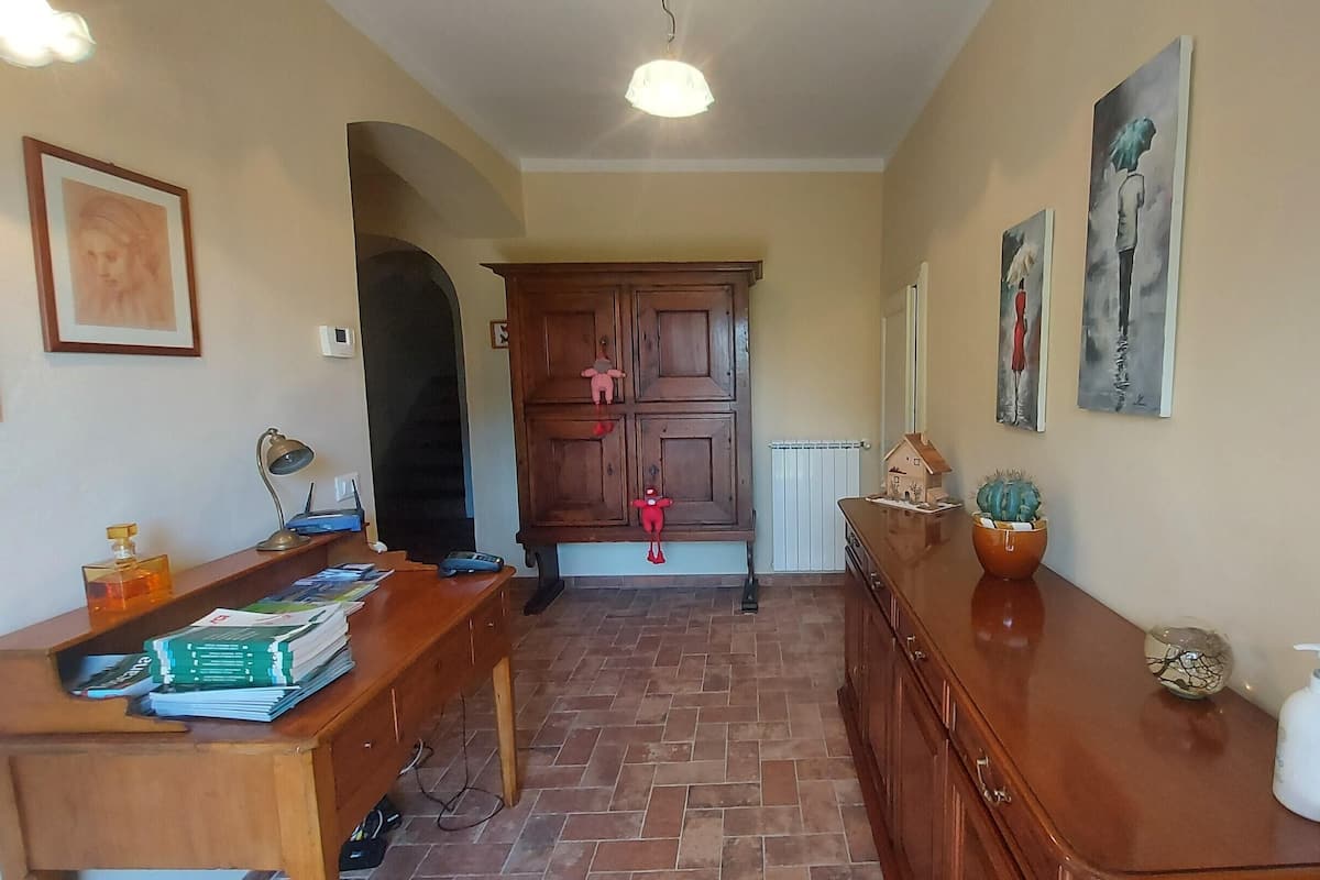 Un couloir avec un banc en bois, un radiateur et un cactus en pot.