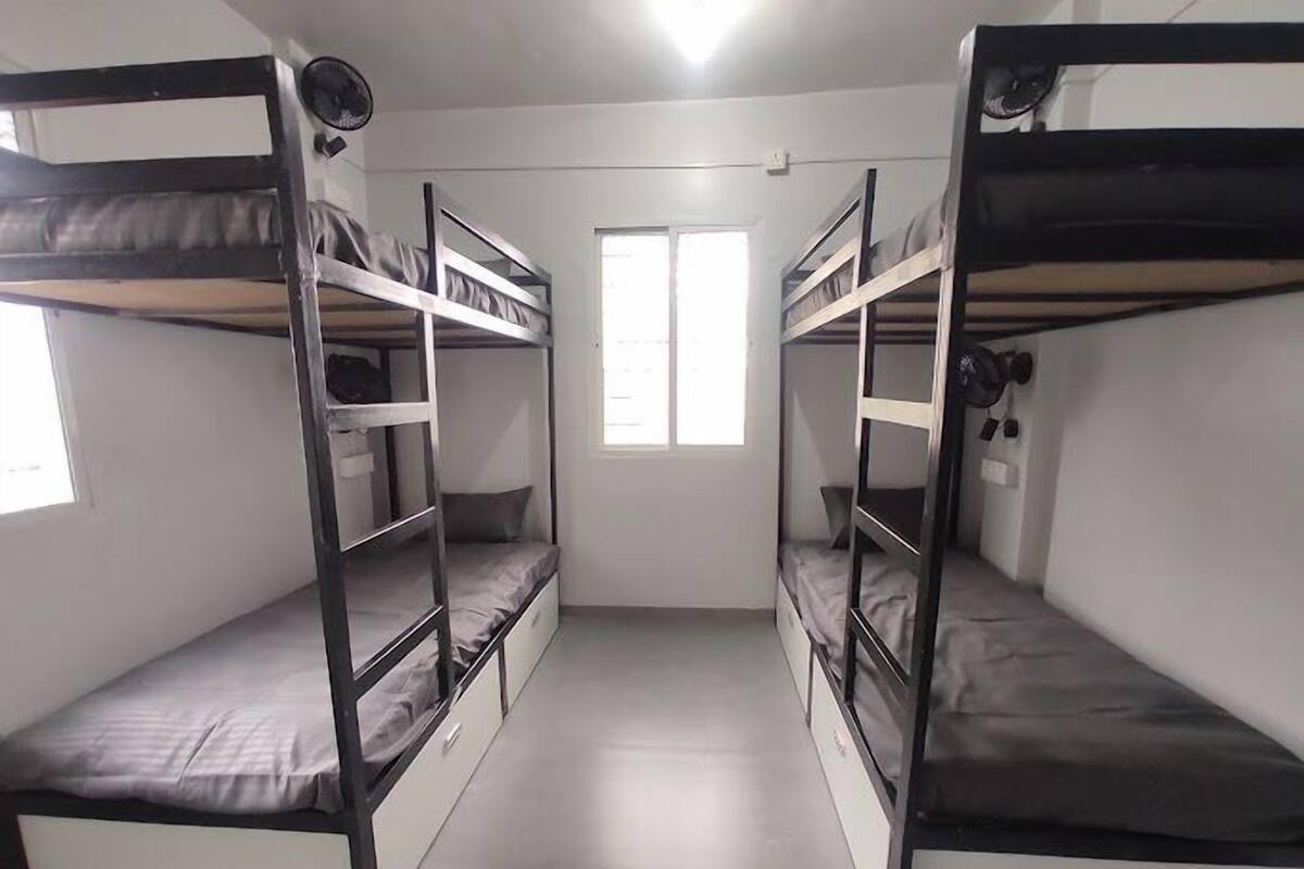 A room with bunk beds, a window, and a fan.