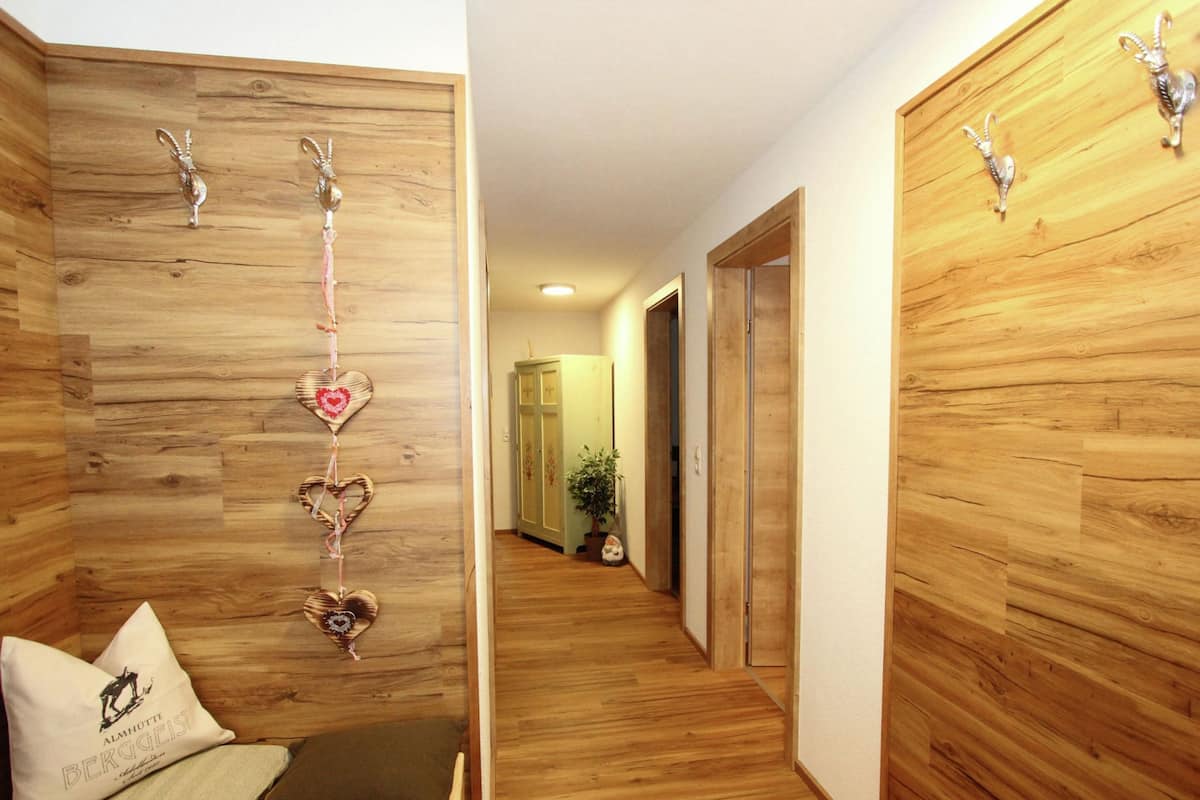 A hallway with wooden walls and a bench with pillows.
