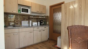 Une cuisine avec des meubles en bois, un four à micro-ondes, un grille-pain et une machine à café.