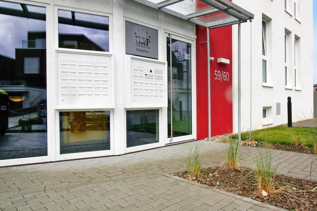 A modern building with a glass reception area, numbered 59/60, and a red accent wall.