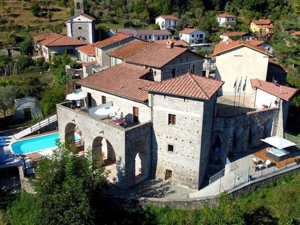A stone building with a swimming pool, multiple rooms, and a tower. - Flat With Heated hot tub and Shared Pool (Casola in Lunigiana)