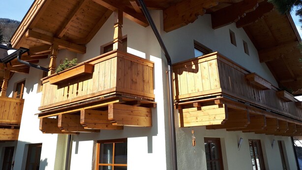 A multi-story building with wooden balconies, a sloped roof, and a visible window. - Apartment in Bramberg am Wildkogel With Parking Space (Bramberg am Wildkogel)