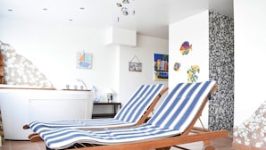 A sun lounger with a striped cushion, a tiled floor, and a wall with a mosaic pattern. - Villa in Altenmarkt With a Balcony (Altenmarkt im Pongau)
