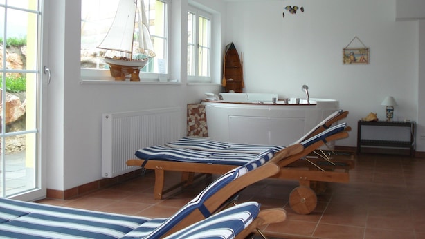 A room with a large window, a sailboat model, a wooden boat, a bathtub, and a small table with a lamp. - Villa in Altenmarkt With a Balcony (Altenmarkt im Pongau)