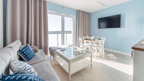 A modern living room with a sofa, coffee table, and dining area. - Modern 2-room Apartment in the new Apartment Complex, Grzybowo (Kołobrzeg)