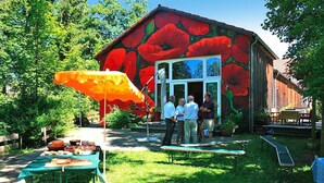 Un edificio rústico con un exterior rojo intenso y un ventanal grande.