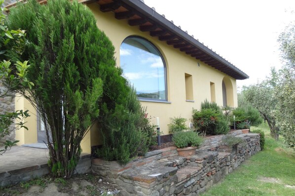 A yellow building with a stone retaining wall, a large window, and various plants. - Holiday Home Cerbaiola, Lamporecchio (Lamporecchio)