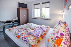Ett hotellrum med en säng, ett skrivbord, två stolar, en garderob och ett fönster med utsikt.