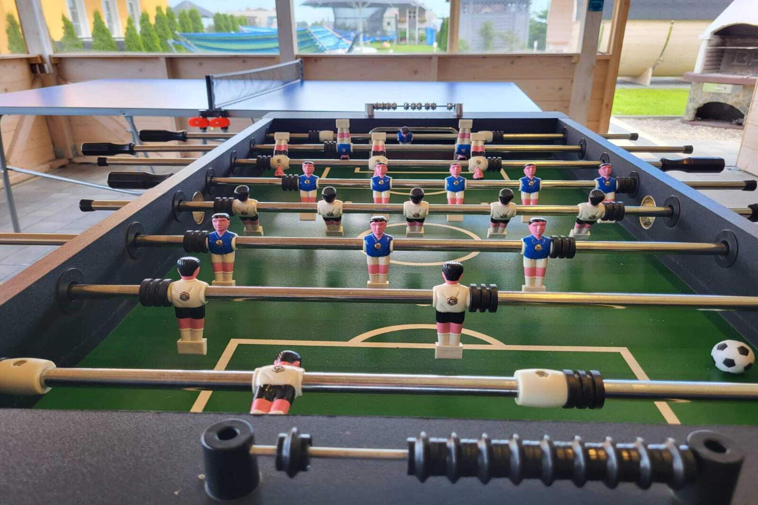 A foosball table with miniature figures in blue and white uniforms.
