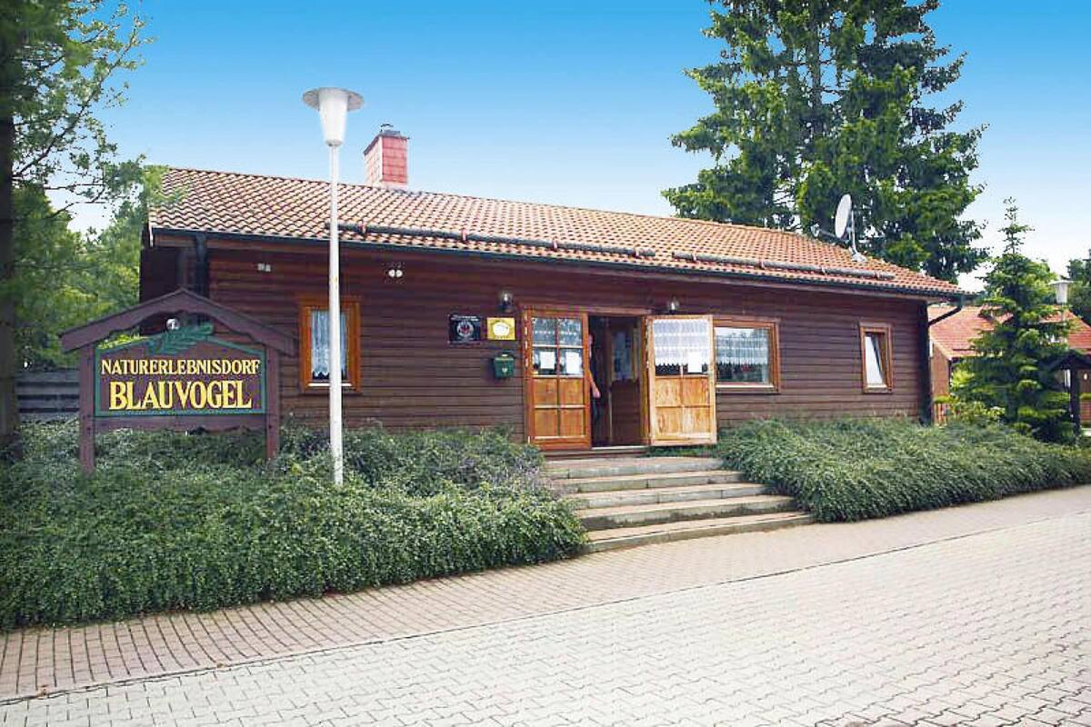 A wooden building with a sign reading "Naturerlebnisdorf Blaubogel".
