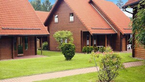 Une rangée de chalets en bois aux toits rouges, une pelouse bien entretenue et un chemin de gravier.