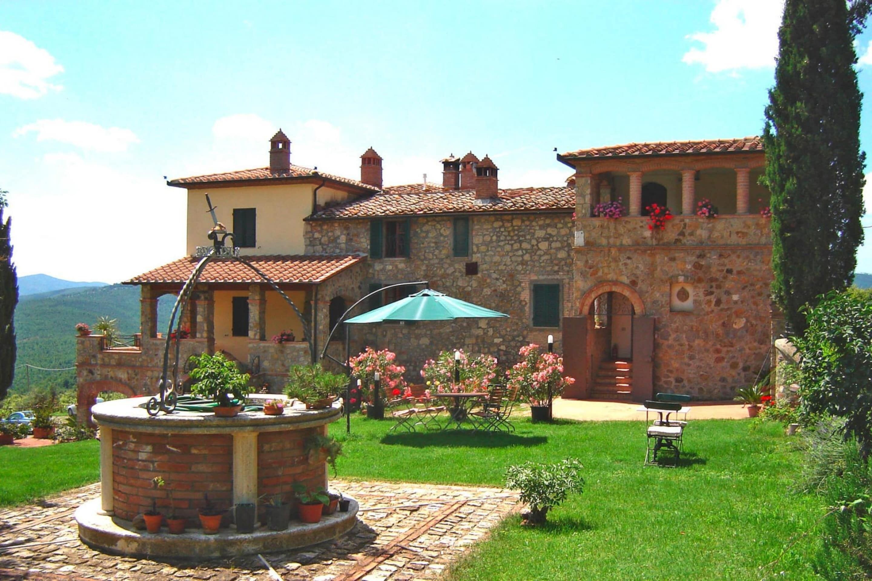 A stone building with a courtyard, a fountain, and outdoor seating.