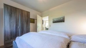 A bedroom with a large bed, a wardrobe, and a painting on the wall. - Apartment in Friedrichskoog-spitze With Parking Space (Friedrichskoog)