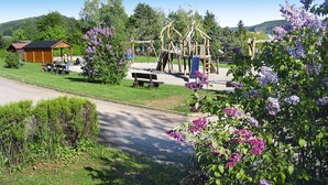Un parque infantil con estructuras para escalar y un pequeño refugio.