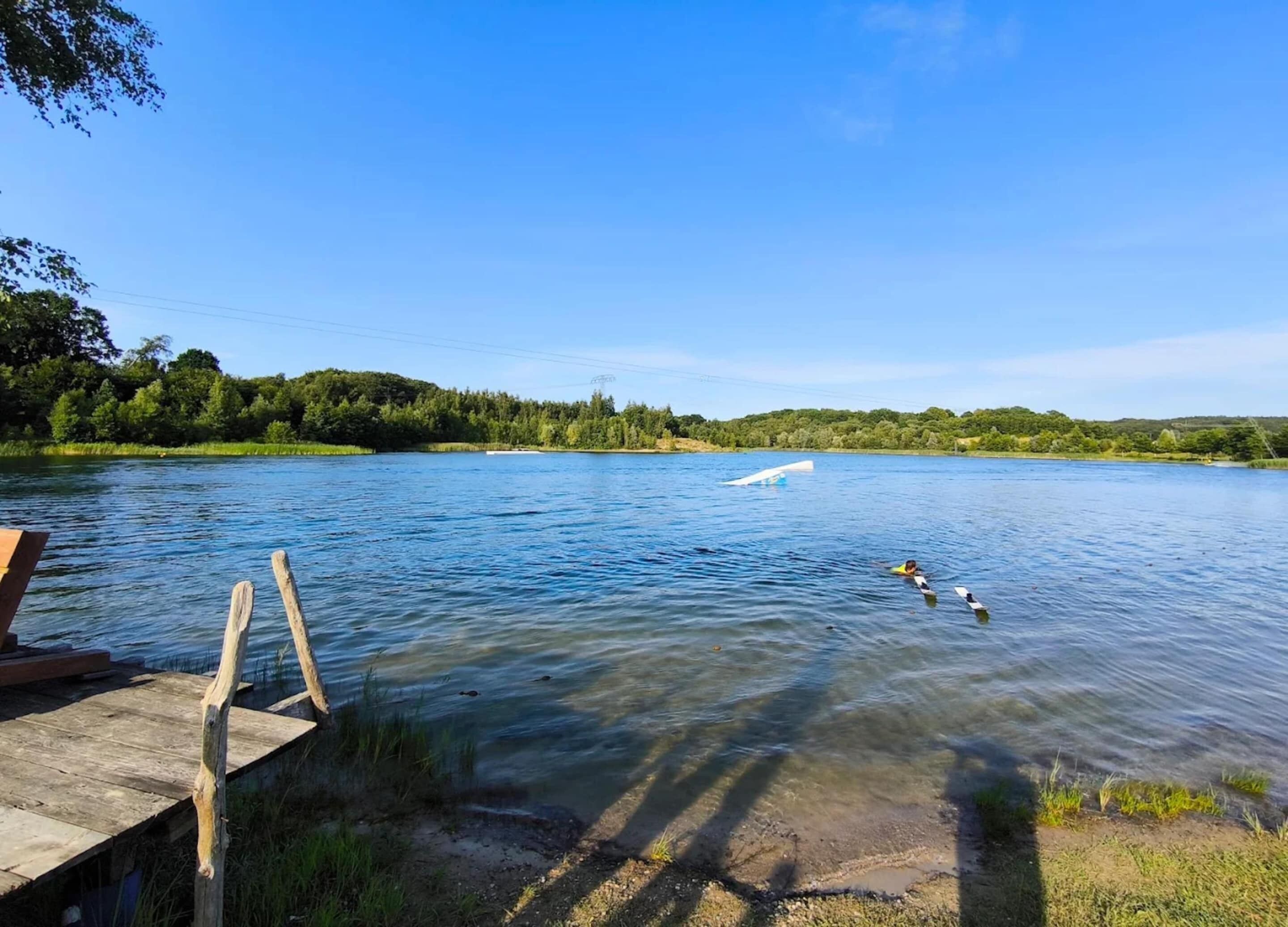 A calm lake with a wooden dock extending into the water.