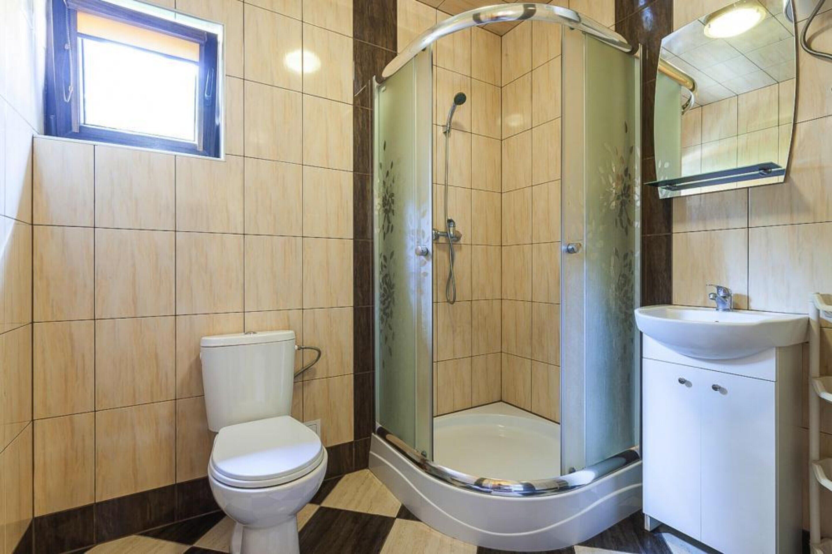 A bathroom with a toilet, a glass-enclosed shower, and a sink.