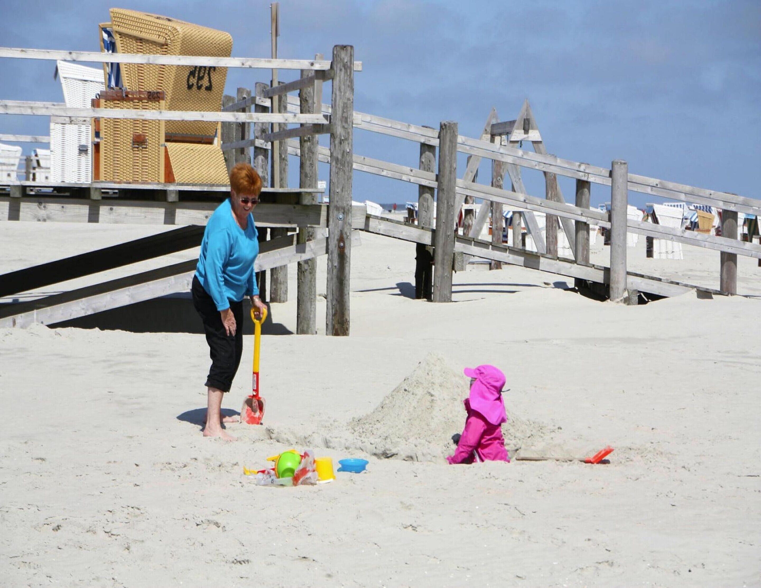 A beach scene with a wooden pier, a lifeguard tower, and a lifeguard chair.