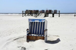 A beach with a row of beach chairs and a single chair in the foreground. - Apartment, Garding (Garding)