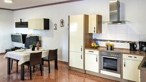 Una cucina moderna con zona pranzo, dotata di forno a incasso, macchina del caffè e lavagna.