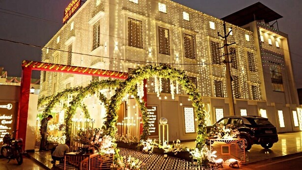 A hotel with a traditional architectural style, featuring multiple windows and a well-lit facade. - THE SHEHNAI RESORT (Alwar)