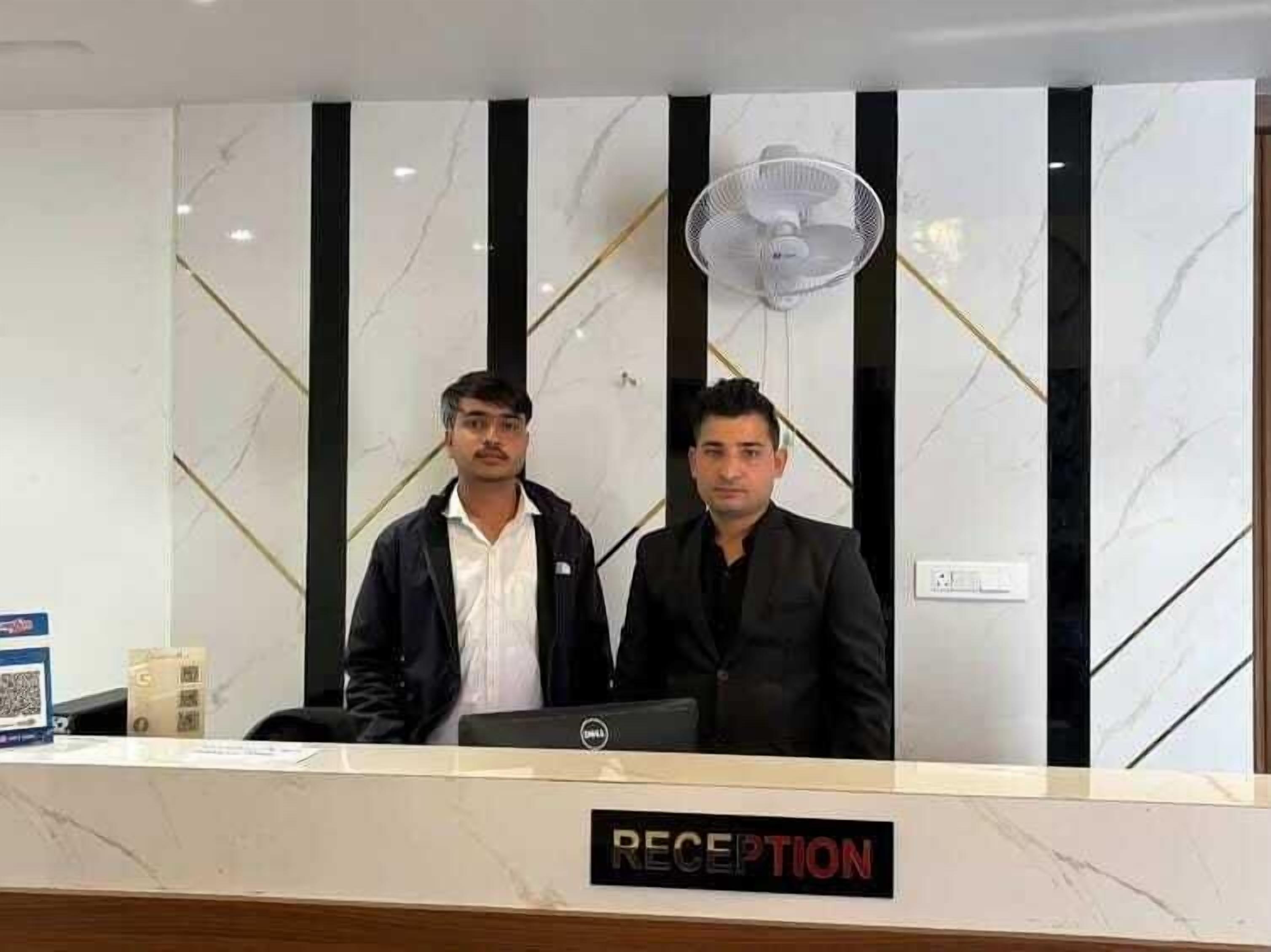 A reception desk with a marble wall and a sign that reads "RECEPTION".