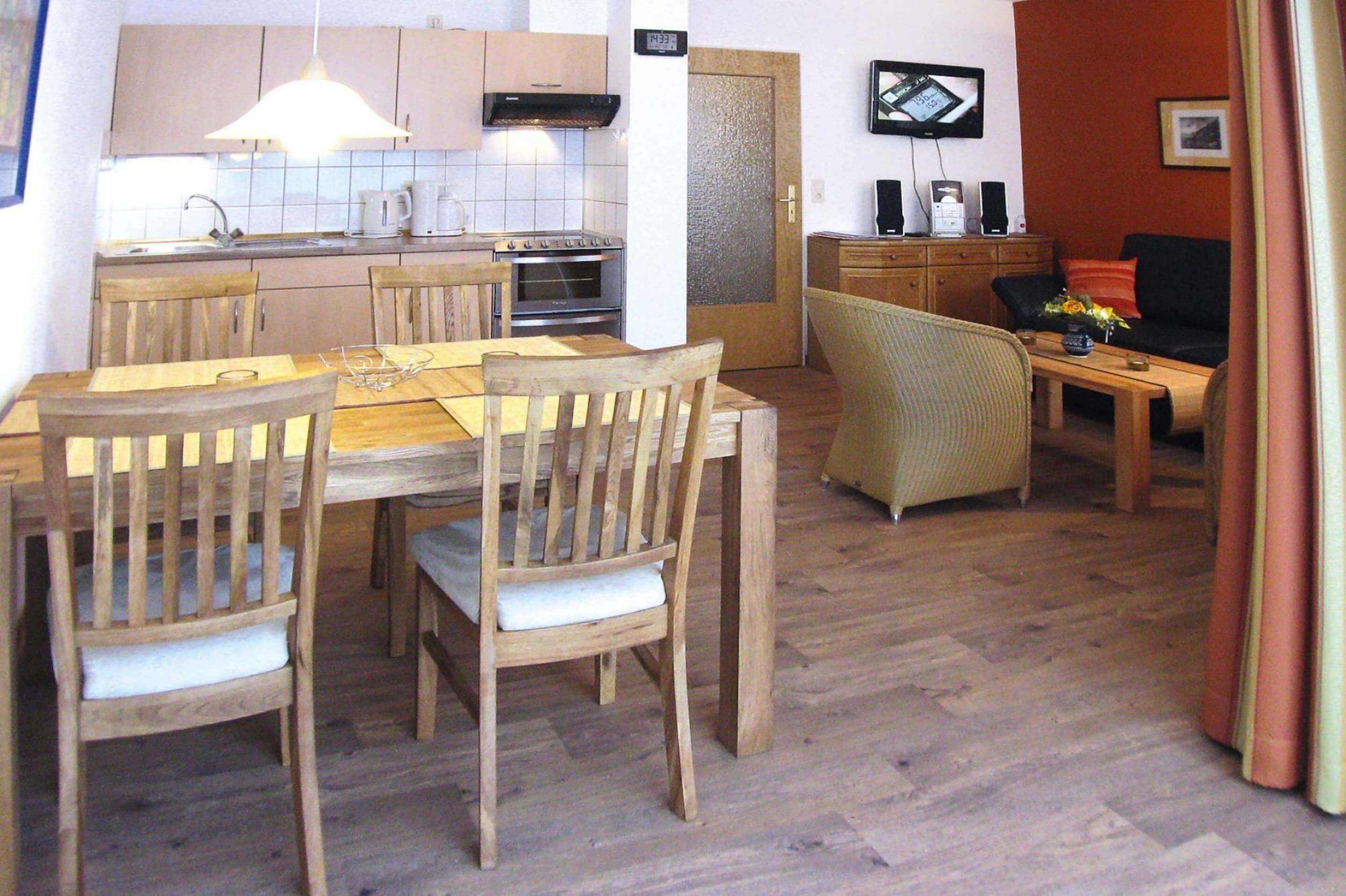 A compact living space with a dining area, kitchen, and a living room.