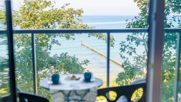 A balcony with a view of the sea, a table with chairs, and a railing. - Apartment Next to the Beach With sea View, Ustronie Morskie (Ustronie Morskie)