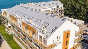 A modern apartment building with multiple balconies, large windows, and a view of the sea. - Apartment Next to the Beach With sea View, Ustronie Morskie (Ustronie Morskie)