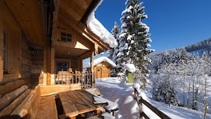 A wooden cabin with a wooden deck and a snow-covered landscape. - Chalet Steinbock, St. Martin am Tennengebirge (Sankt Martin am Tennengebirge)