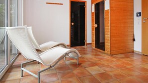 A room with two white wicker chairs, a wooden door, and a tiled floor. - Holiday Resort in the Muritz National Park, Mirow (Mirow)