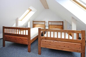 A loft bedroom with two wooden beds, a skylight, and a sloped ceiling. - Holiday Resort in the Muritz National Park, Mirow (Mirow)