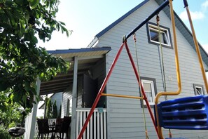 Ein Haus mit Veranda, Schaukel und Fenster.