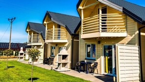 A row of modern cabins with balconies, outdoor seating, and a barbecue area. - Holiday Resort With Pool, Whirlpool, Sauna, Ustronie Morskie (Ustronie Morskie)