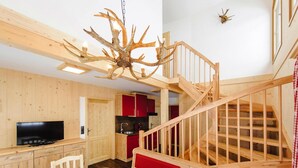 A wooden interior with a dining area, a television, a staircase, and a kitchen. - Holiday Home in Gaal im Murtal in a Beautiful Setting (Gaal)