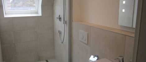 A bathroom with a shower, toilet, and sink.