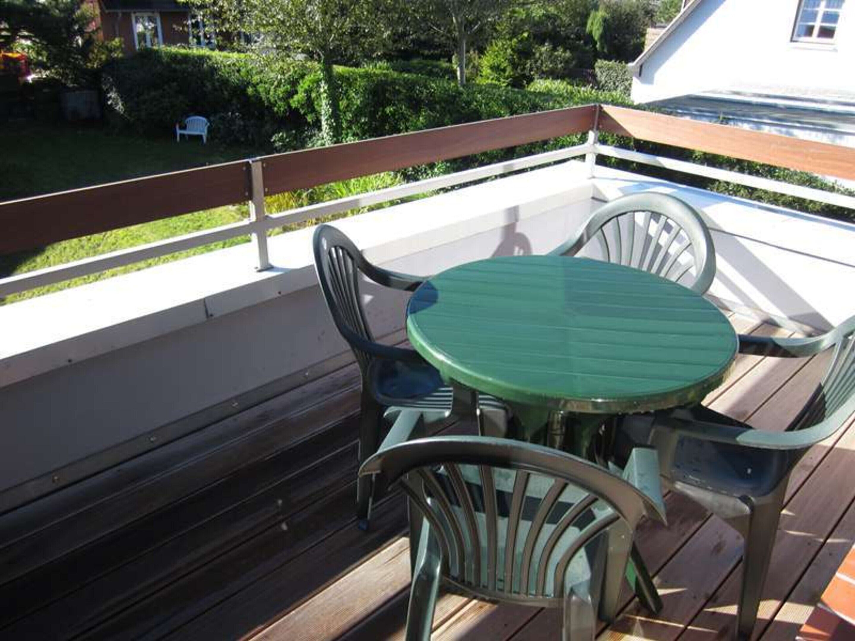 A wooden deck with a round table and two chairs.