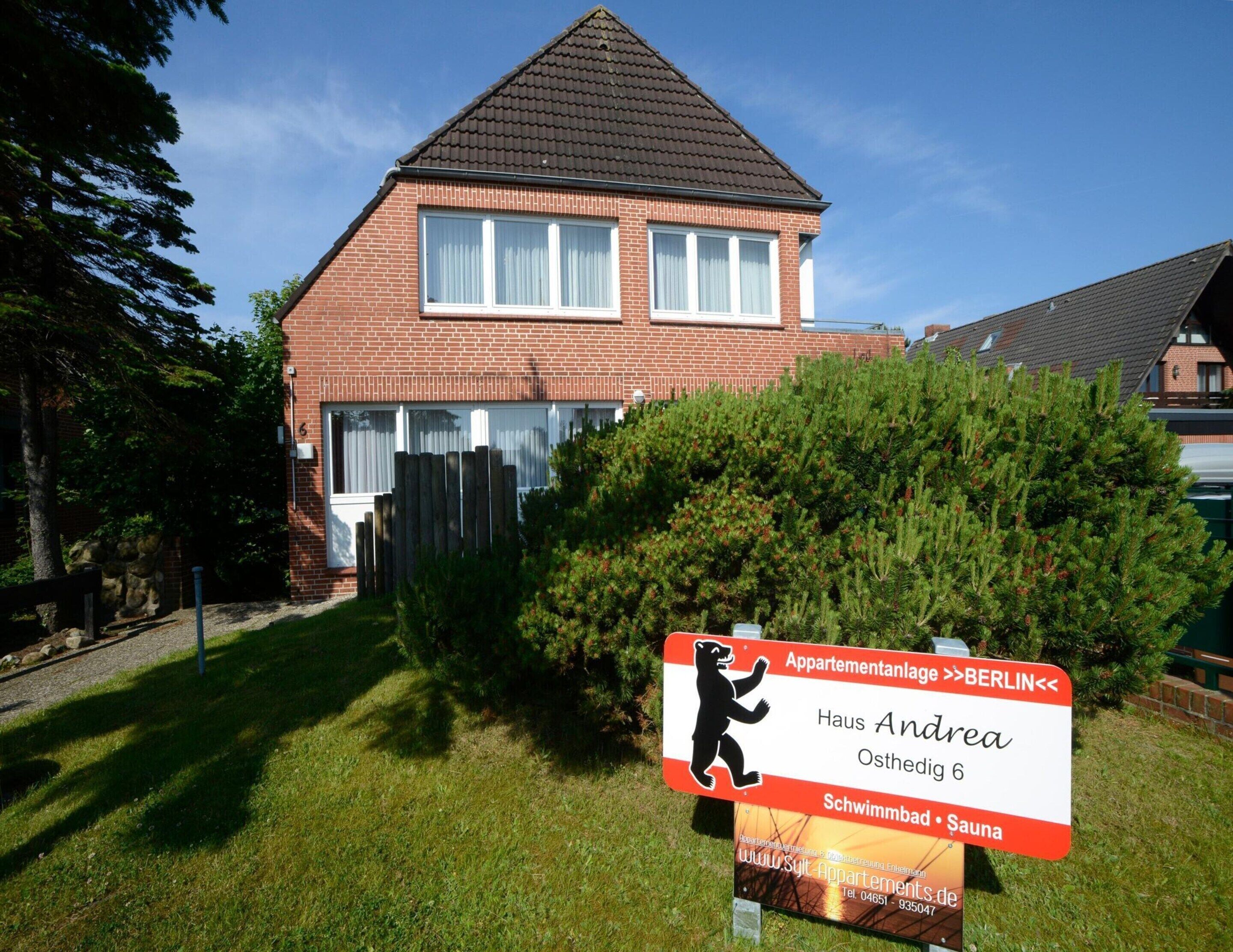 A two-story house with a brick facade and a tiled roof.