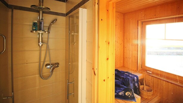 A wooden cabin with a glass shower enclosure, a window, and a towel rack. - Semi-detached House, Ostseeresort Olpenitz (Kappeln)