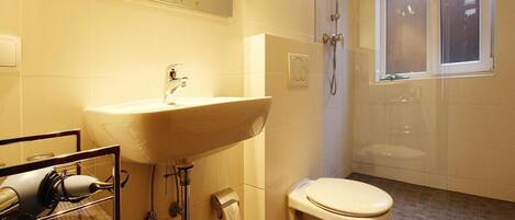 A bathroom with a sink, toilet, and shower.
