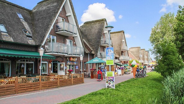 A street with traditional buildings, outdoor seating, and a clear sky. - Seepark Burhave, Burhave (Butjadingen)