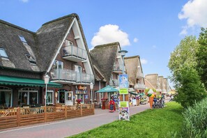 A street with traditional buildings, outdoor seating, and a clear sky. - Seepark Burhave, Burhave (Butjadingen)