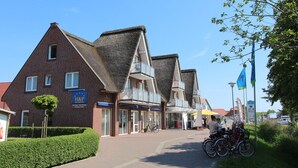 A street with traditional buildings, a clear sky, and bicycles parked on the side. - Seepark Burhave, Burhave (Butjadingen)