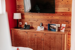 A wooden cabinet with a telephone, a remote control, and a brochure. - Ferienhauser im Schierke Harzresort (Wernigerode)