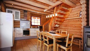 A log cabin interior with a kitchen, dining area, and a wooden staircase. - Blockhaus, Schierke (Wernigerode)