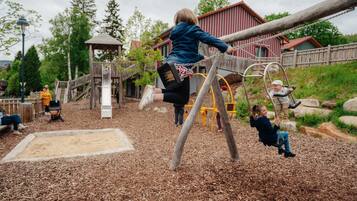 A playground with wooden structures and a covered playhouse.