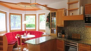 A kitchen with wooden cabinets, a granite countertop, and a built-in oven. - Holiday Home Emberger, Fugen (Fuegenberg)