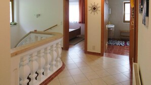 A hallway with a staircase, a bathroom with a shower, and a tiled floor. - Holiday Home Emberger, Fugen (Fuegenberg)