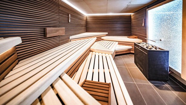 A modern sauna with wooden benches and a stone basin. - Apartments in the Maremuritz Yachthafen Resort, Waren an der Muritz (Waren (Müritz))