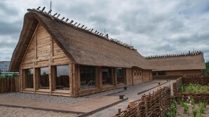 A wooden building with a thatched roof and large windows. - Ferienhaus im Ostseeresort Dampland in Perfekter Lage (Damp)